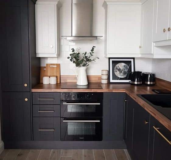 Two tone white and black cabinets, wooden countertop and range hood kitchen design