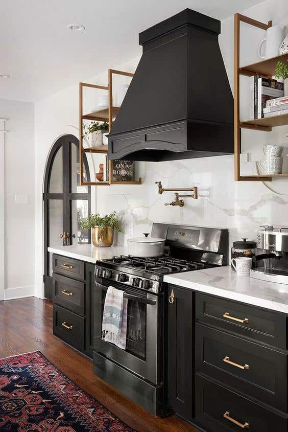 Gold hardware on black kitchen cabinets, marble wall backsplash and open shelving design