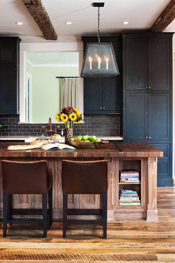 Rustic Kitchen design with black cabinets, black subway tiles and natural wood island