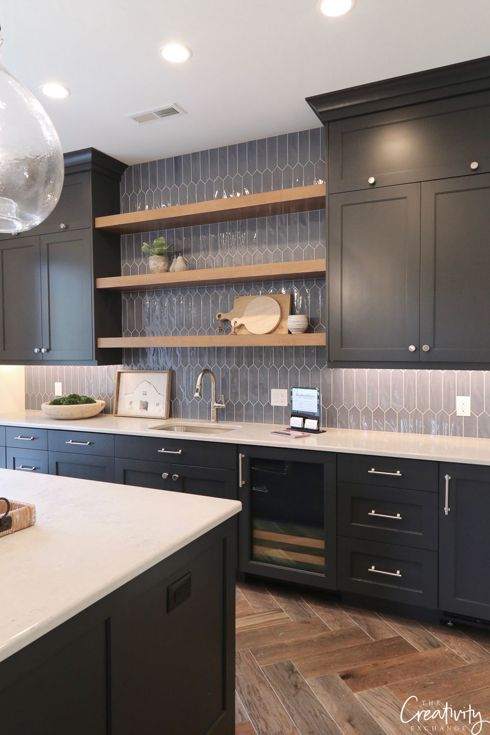 Silver hardware on black cabinets, Open shavelings and wooden flooring 