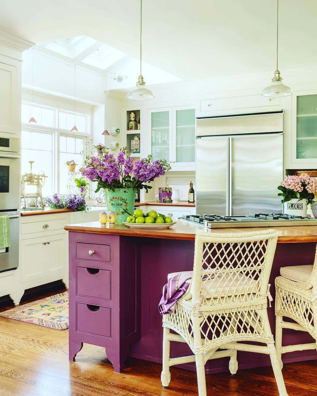White kitchen cabinets paired with Purple Color kitchen island and wooden countertops, stainless steel appliances 