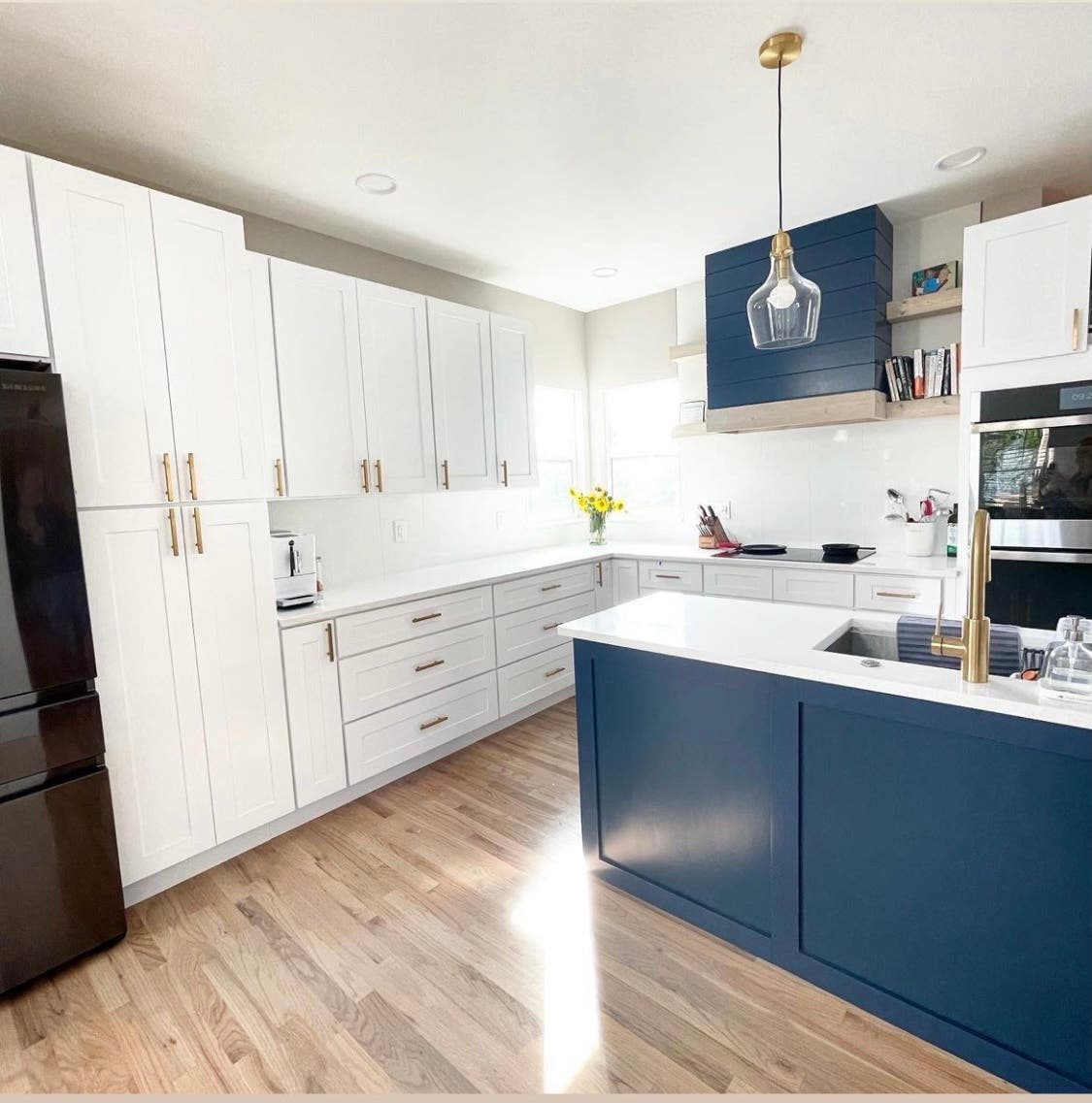 two toned white and blue cabinets with white countertops and wooden flooring 