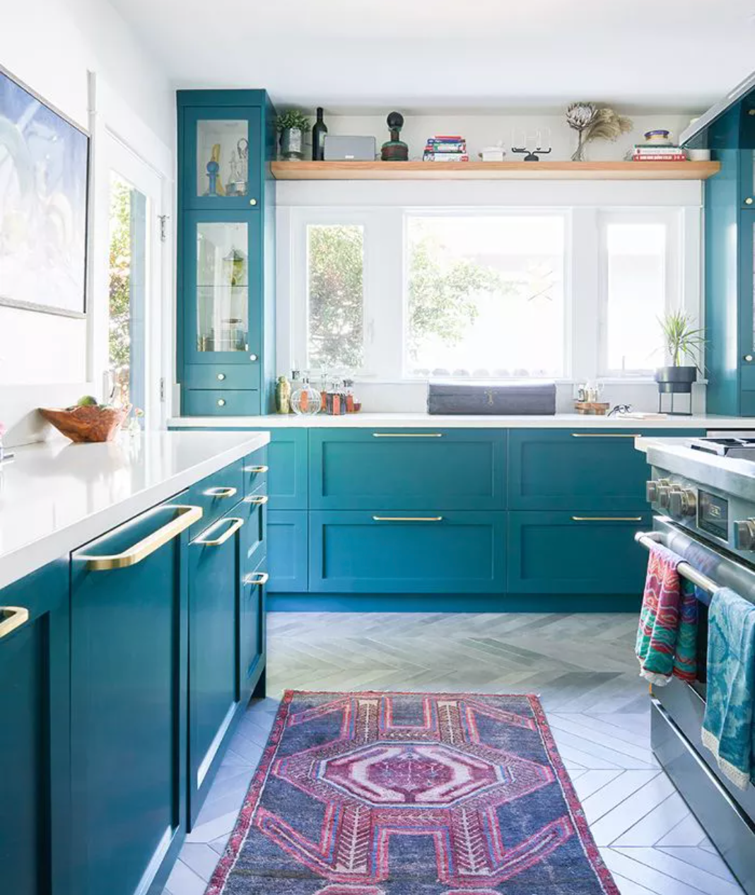 Vibrant blue kitchen cabinets paired with white quartz countertops and gold hardware