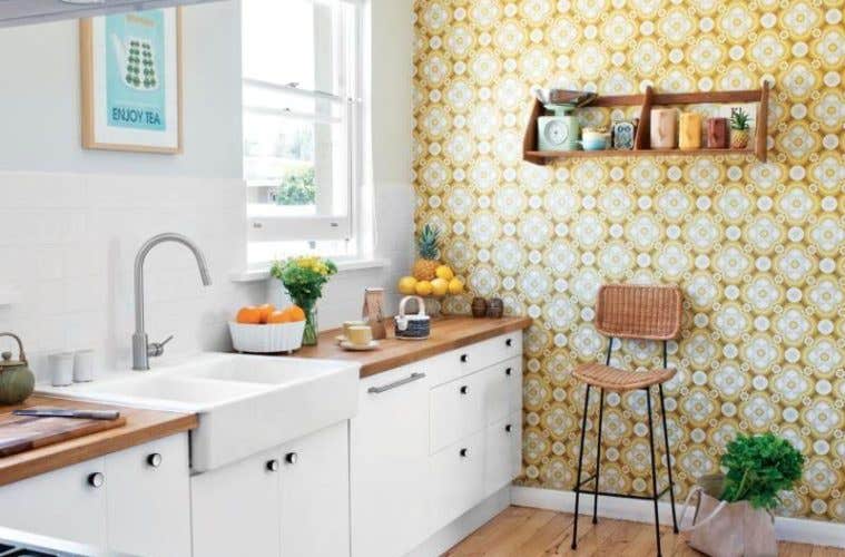 White cabinets paired with bright wallpapered, wooden countertops and farmhouse sink 