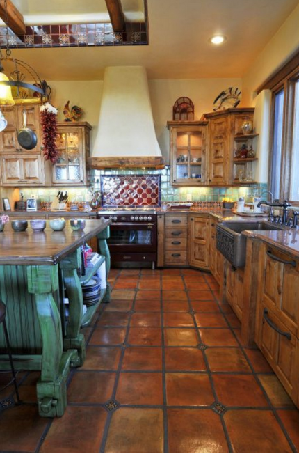 hispanic rustic kitchen with colored tiles, green painted island, hispanic decor and range hood stove