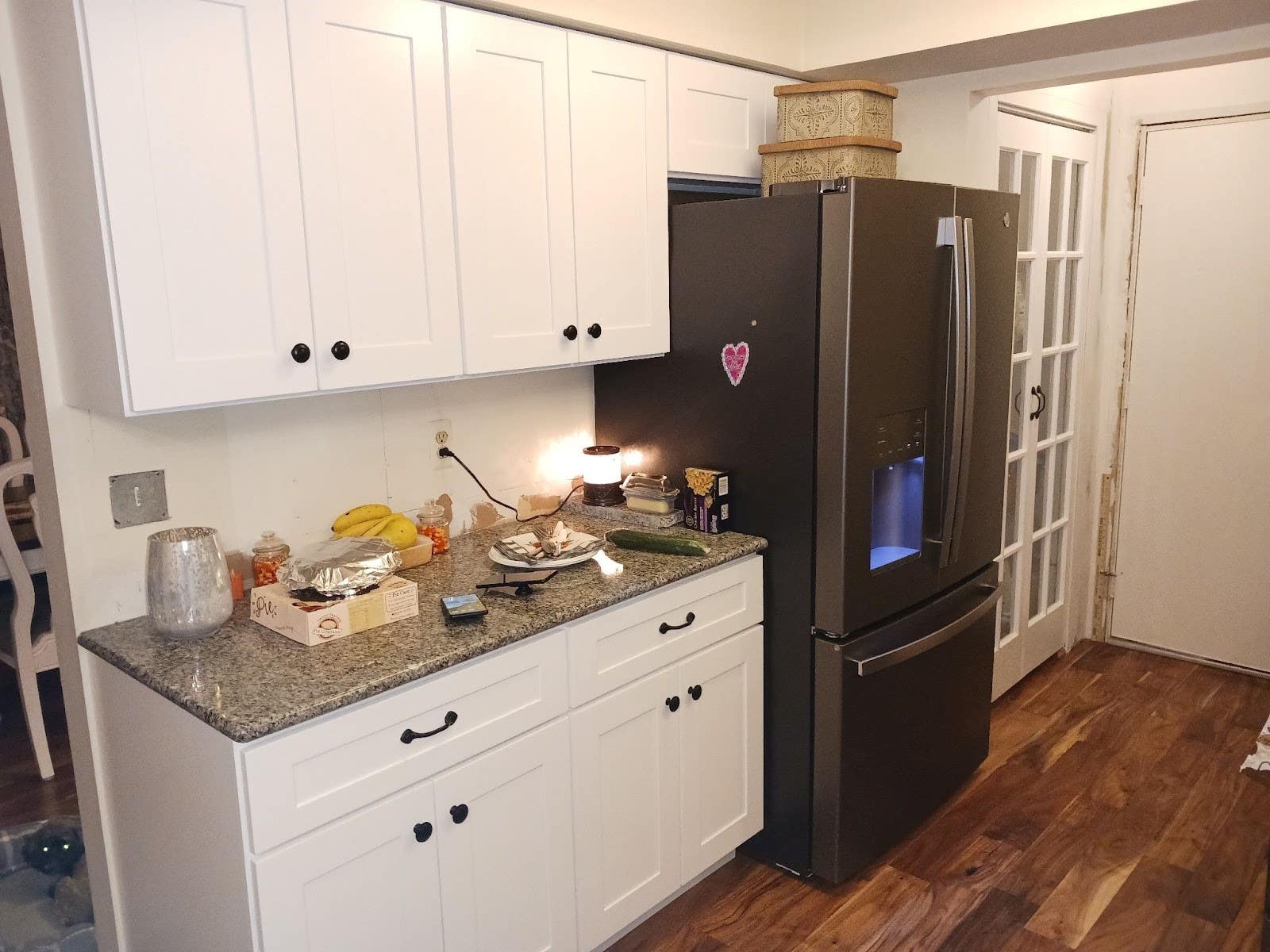 White cabinets paired with slate appliances and wooden flooring 