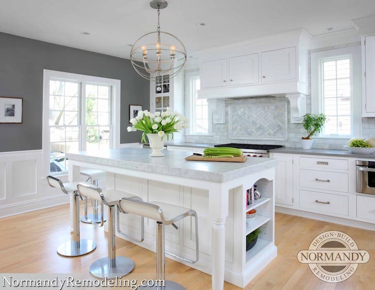 Deep grey wall color paired with white cabinets and wooden flooring