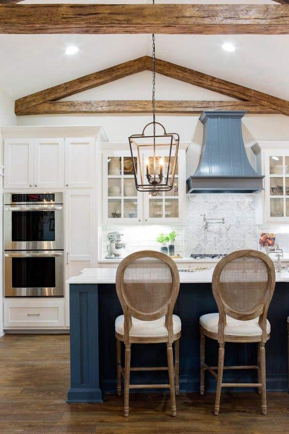 Blue and white kitchen with shaker cabinets and wood Hood