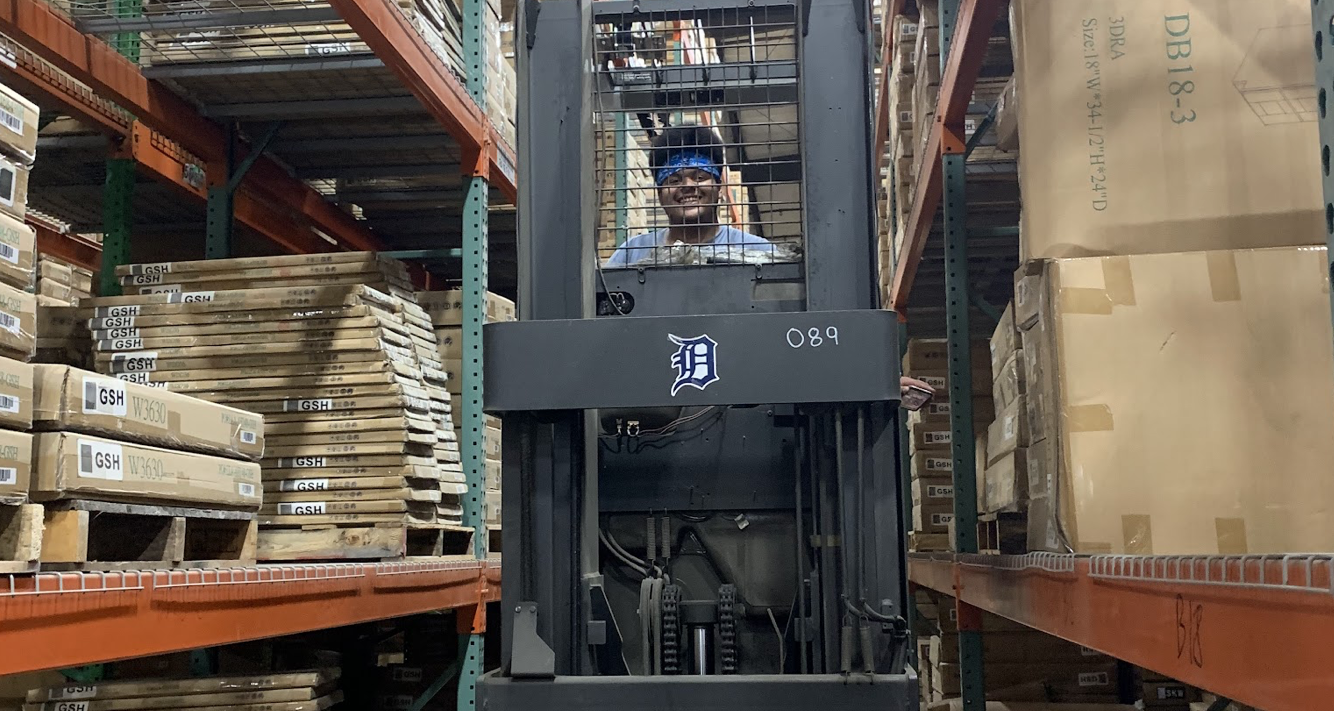 A Man in Warehouse with cabinet stocks
