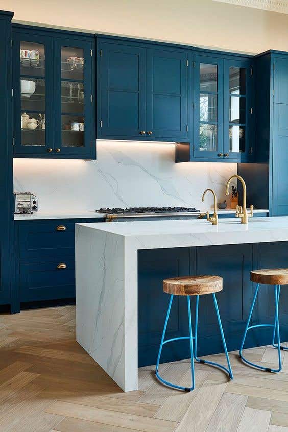 Matching countertop and backsplash with blue kitchen cabinets