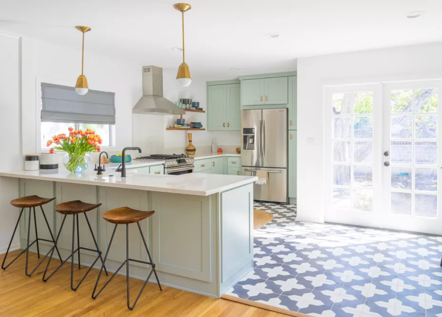 Minty fresh color kitchen cabinets paired with white wall and pattern tile flooring 