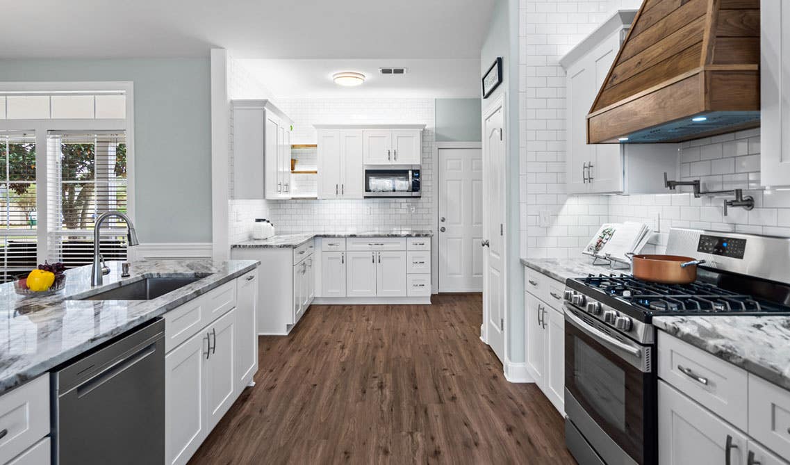 Aesthetics White kitchen design with shaker cabinets, wood accent and stainless steel appliances 