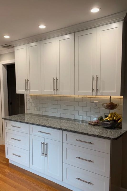 White cabinets paired with white subway tiles and granite countertop 