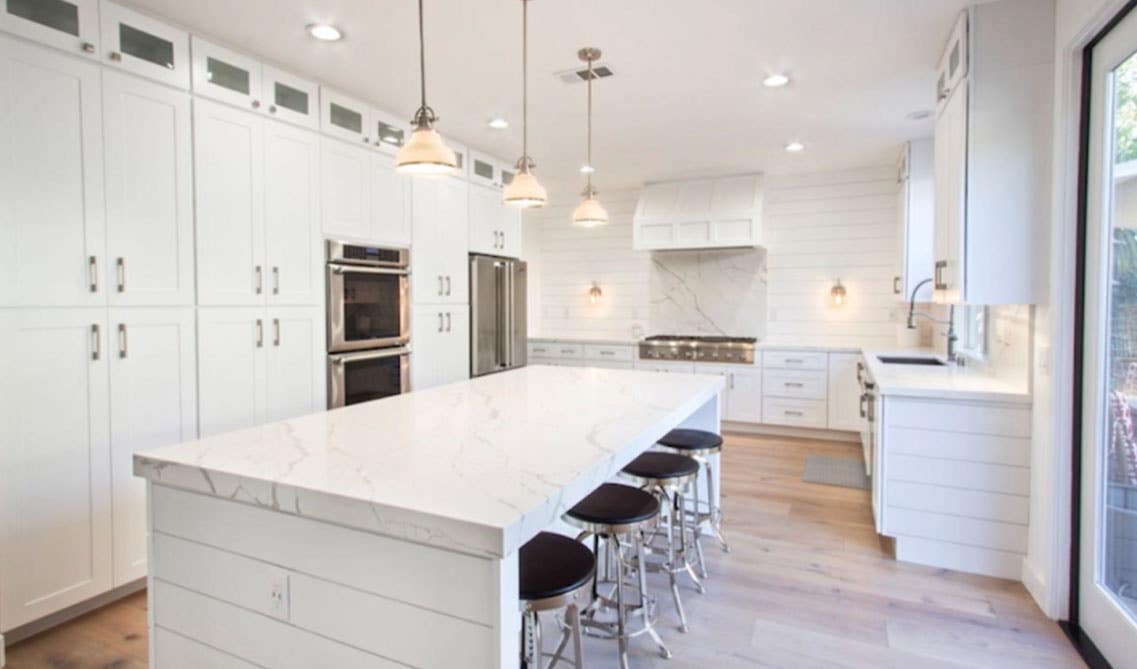 All white cabinets with large island and spc flooring