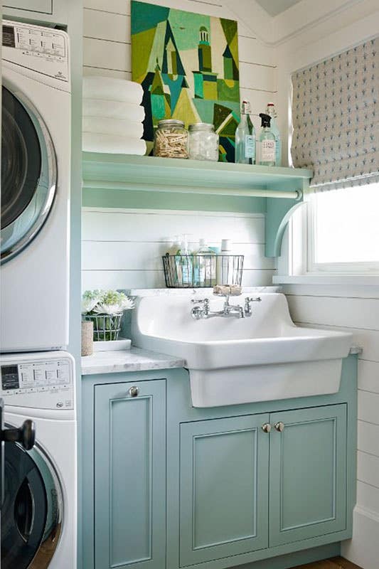 Laundry room with washer and dryer and open shelving for storage with nice wall art 