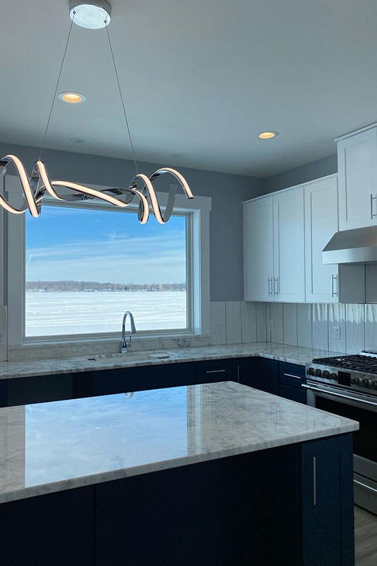 two tone kitchen with shiplap backsplash and LED chandelier