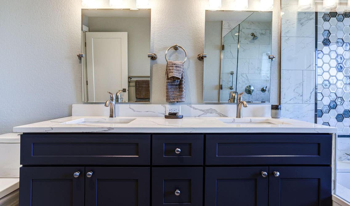 navy blue bathroom vanity with marble countertop, double sink and mirror 