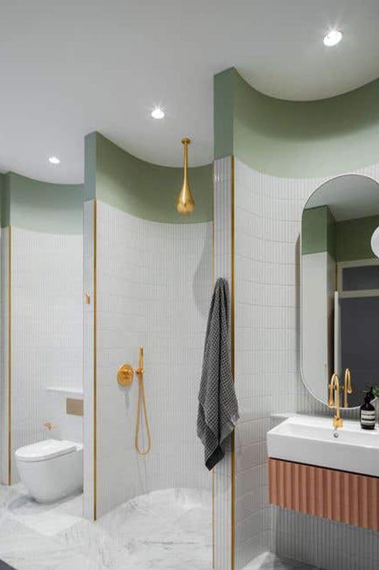bathroom design with curved walls, gold hardware and floating vanity