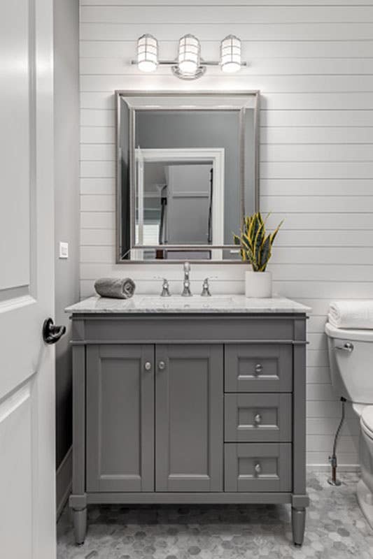 Bathroom with Gray vanity cabinet, square mirror, vanity light, and horizontal shiplap wall 