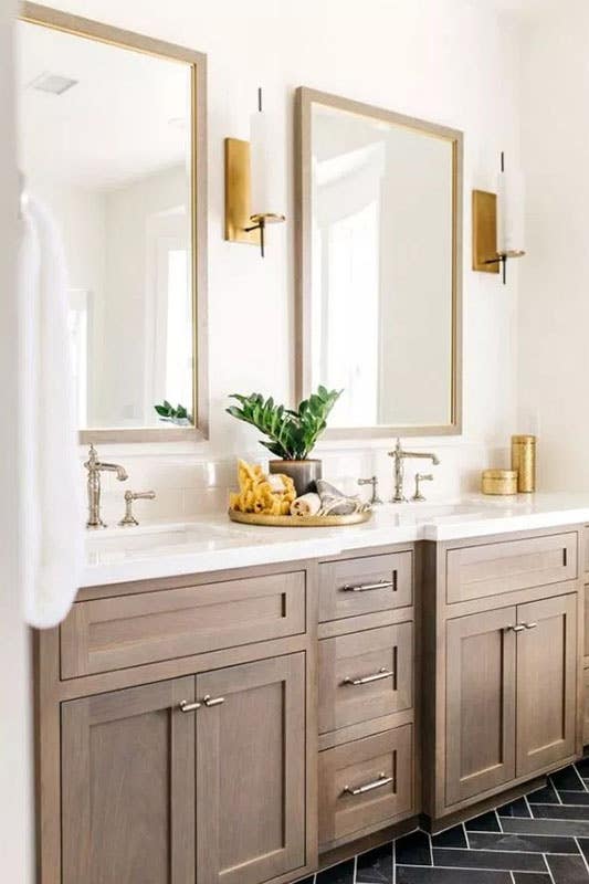 contemporary bathroom design with wood shaker cabinets, brass hardware, double sinks and white countertop