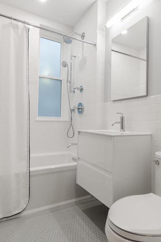 White bathroom design with stainless steel bathroom fitting and fixtures, wall mounted vanity and square mirror