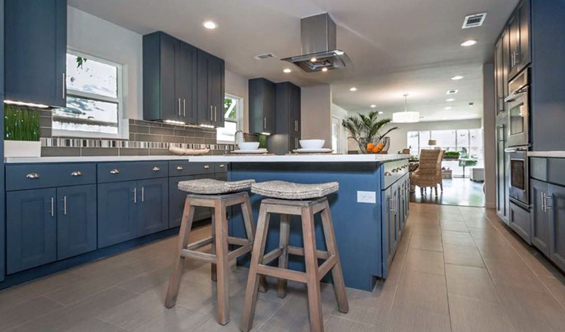 sapphire blue kitchen cabinets paired with white countertops and white walls