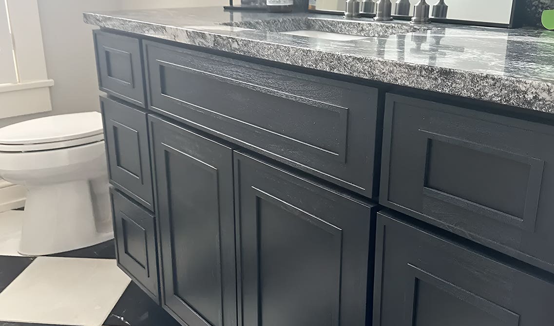 Black bathroom vanity with marble countertop