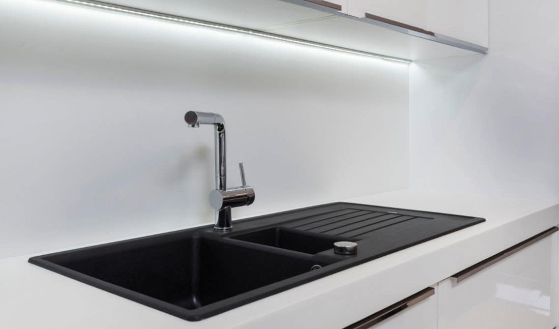 Black matt sink with stainless steel faucet and white cabinets 