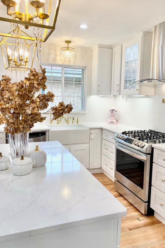 Modern kitchen style with white cabinets, farmhouse sink and Brass Kitchen Lighting