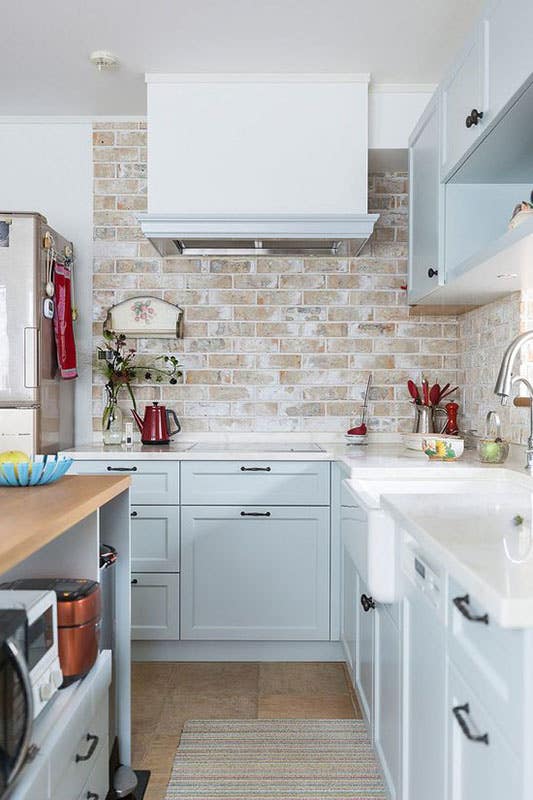 Painted Brick Backsplash with White Rangehood and bright white cabinets