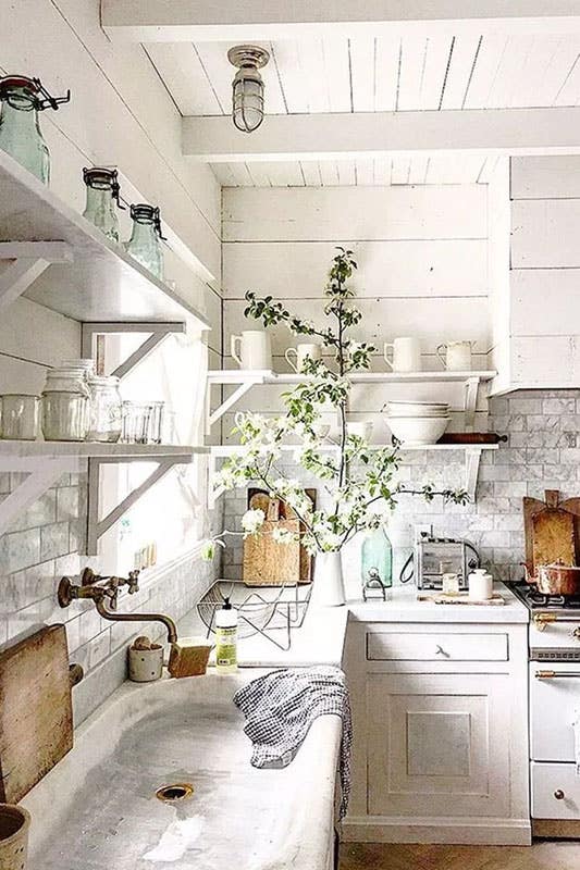 classic farmhouse kitchen with shiplap walls, white vintage cabinets, small farmhouse cabinets, cement countertops, large basin sink and vintage farmhouse decor