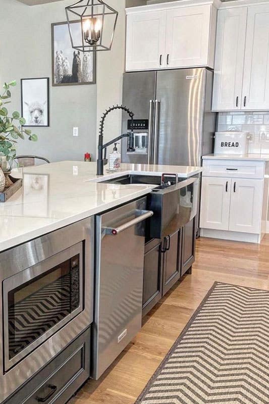 Farmhouse kitchen with Bright White cabinets Paired With a Dark Grey Island and stainless steel appliances