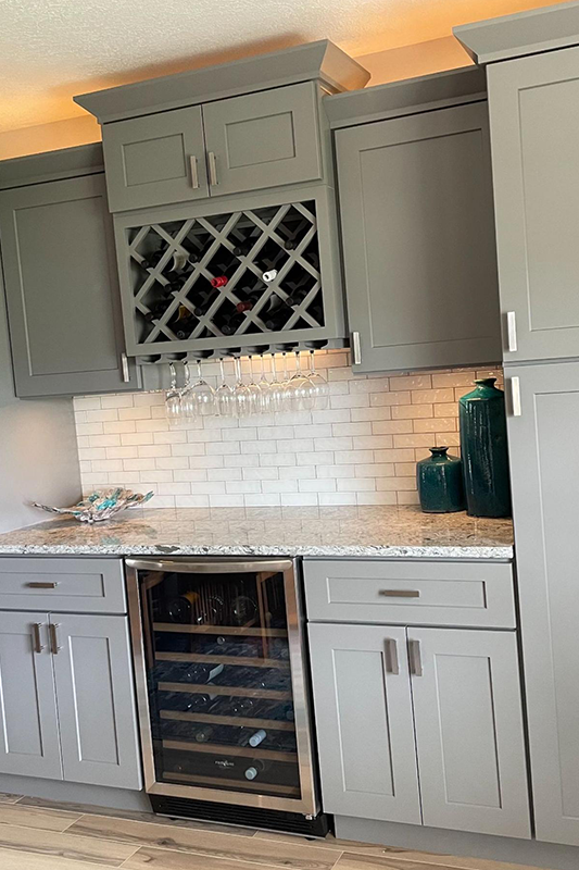 Built-in wine rack in gray shaker storage cabinets