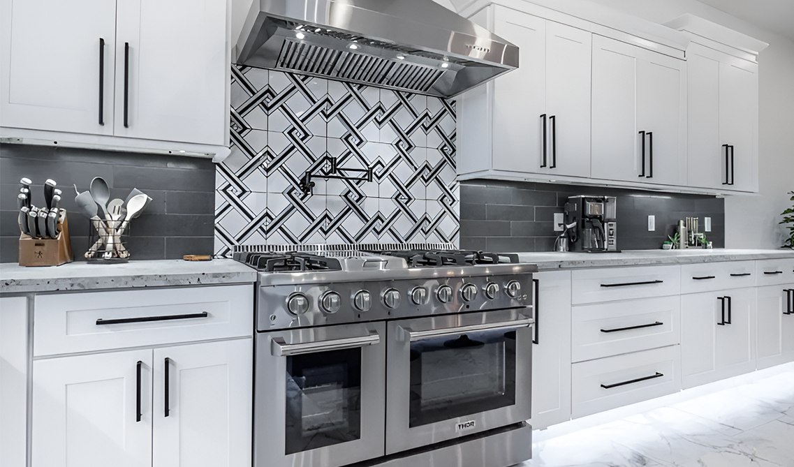 White shaker kitchen cabinets paired with stainless steel appliances and black hardware