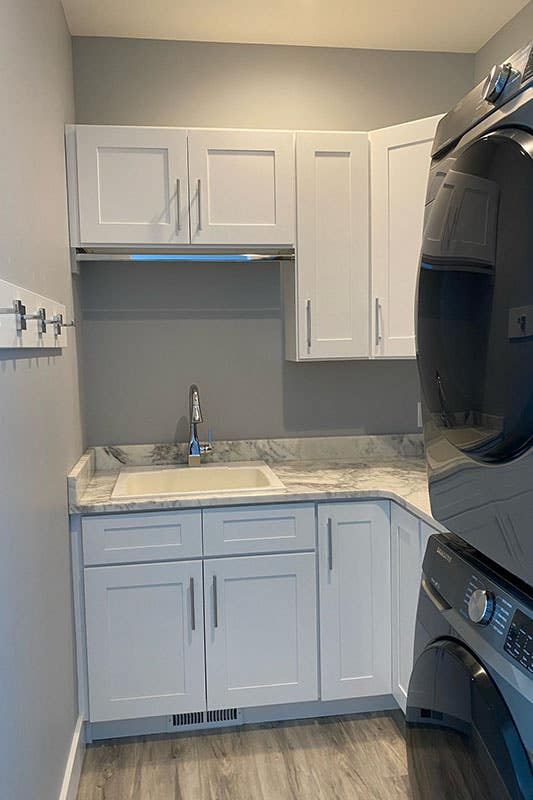 Small Laundry room with washer and dryer and white cabinets s