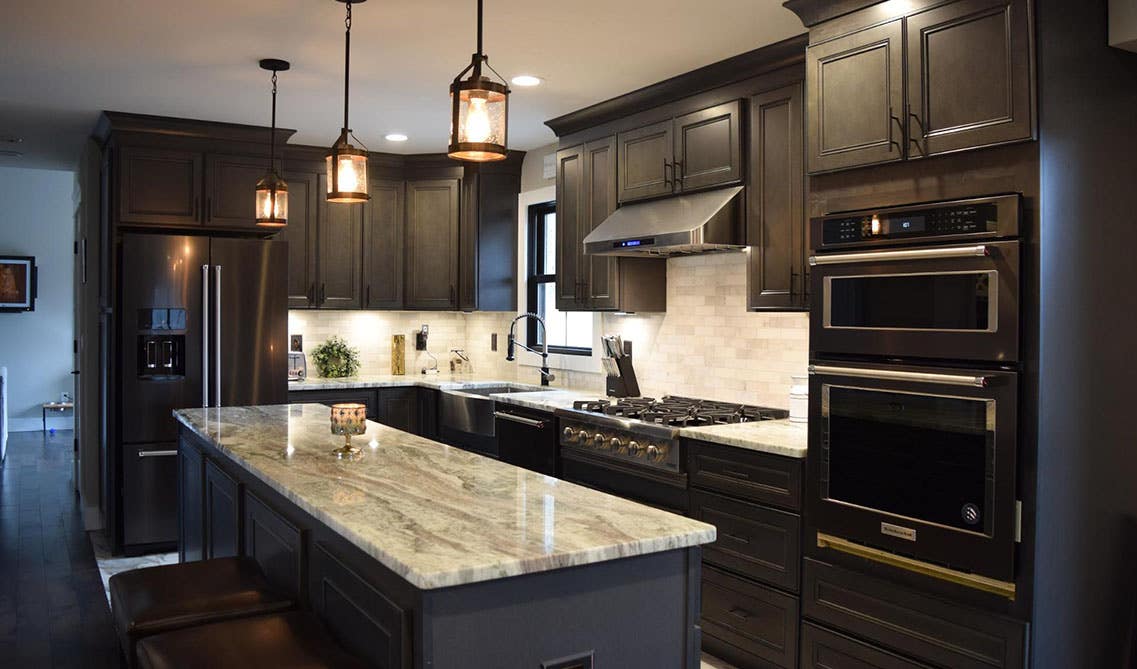 Dark Cabinets to the Ceiling with large island and pendant lighting 