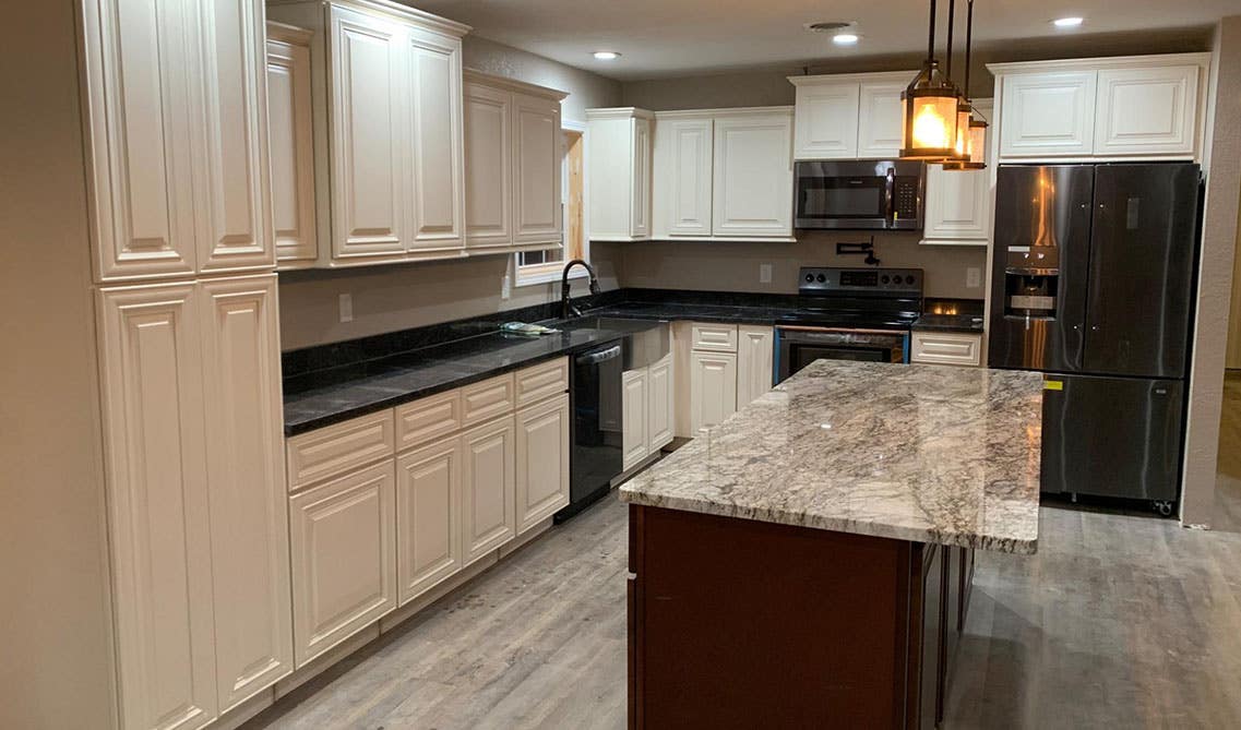 Charleston Linen Kitchen Cabinet Paired with Black Appliances and Pendent lights