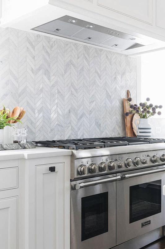 Modern kitchen with Chevron Pattern tile backsplash and white cabinets