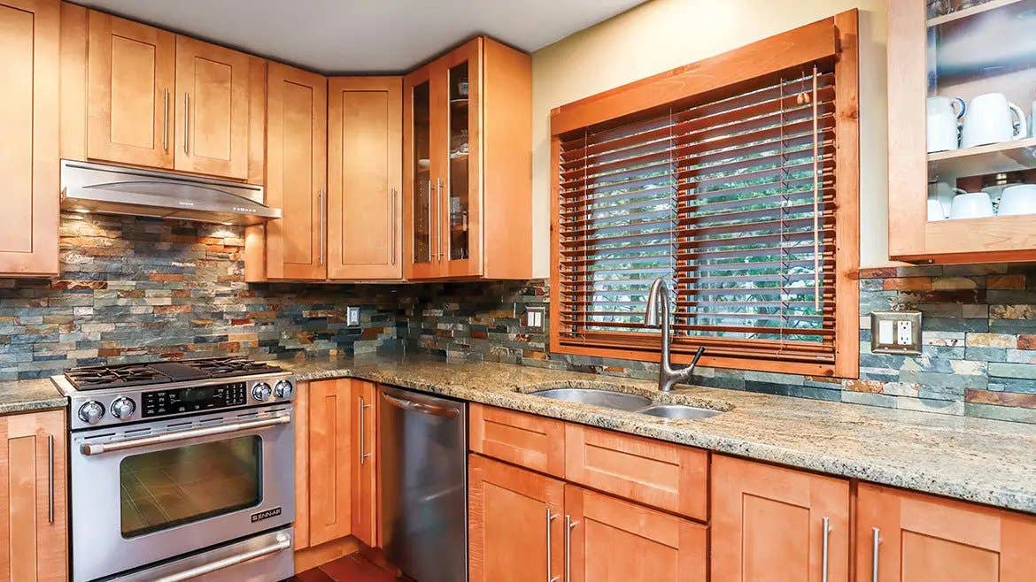 Shaker Cinnamon kitchen cabinets paired with concrete countertop and stainless steel appliances 