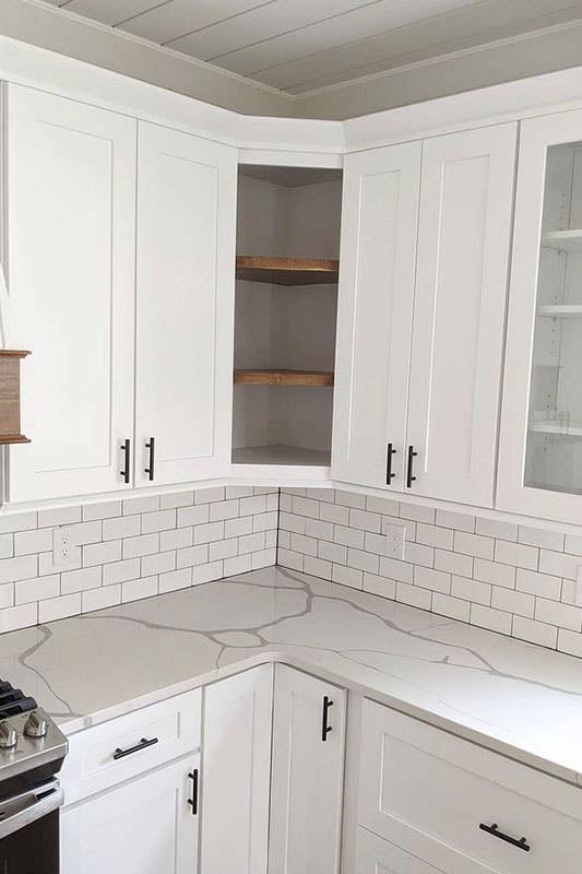 Modern kitchen with Subway Tile backsplash and white glass cabinets