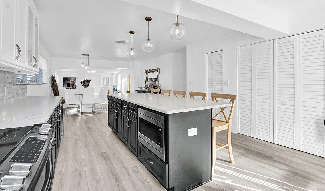 white inspire kitchen with two tone cabinets with island and pendant lights