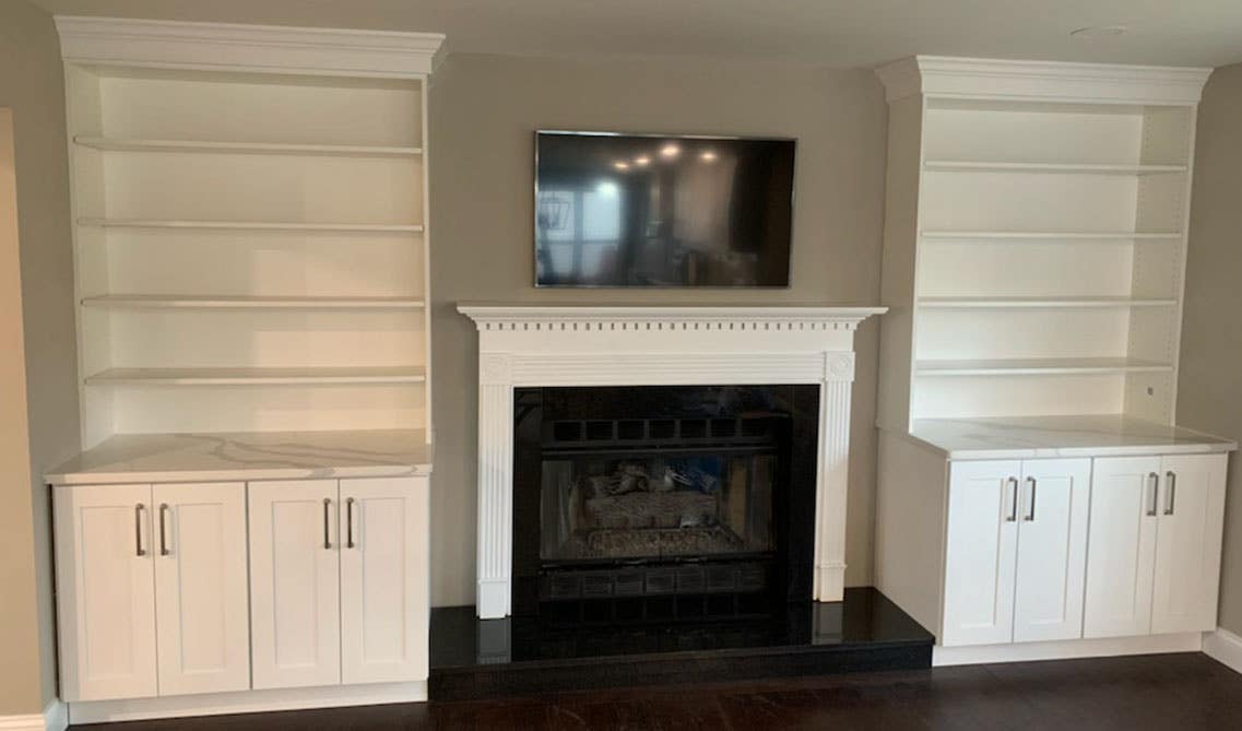 Wood burning fireplace with white storage cabinets