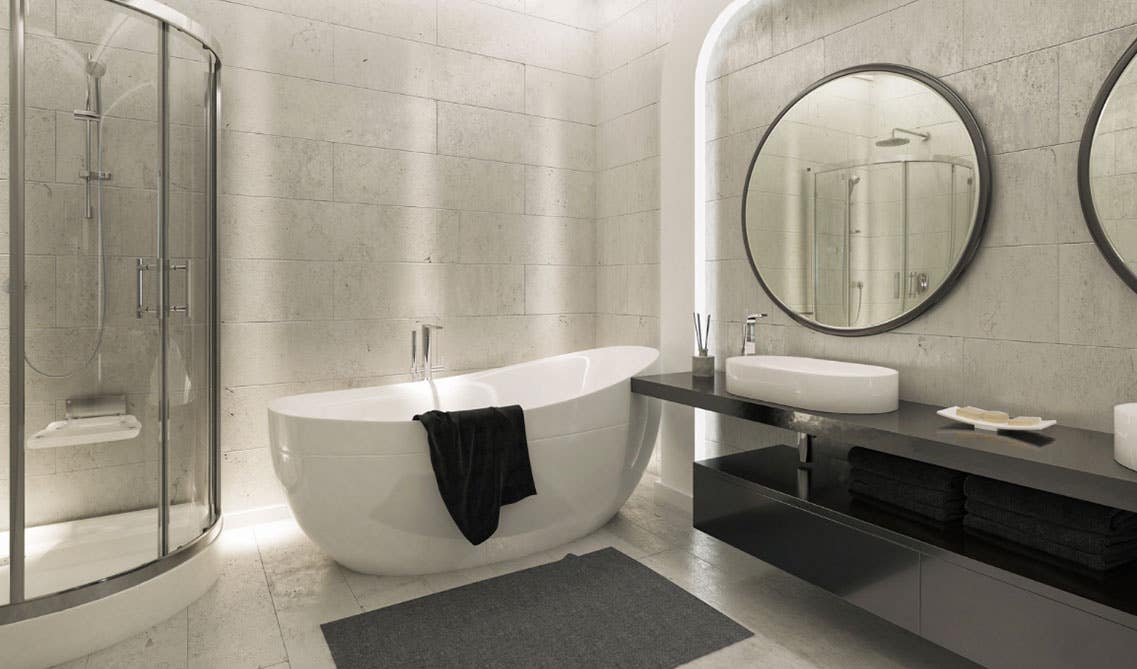 Stylish bathroom features wall mounted vanity with black concrete countertop, double sink and mirrors and large white bath tub, separate shower area