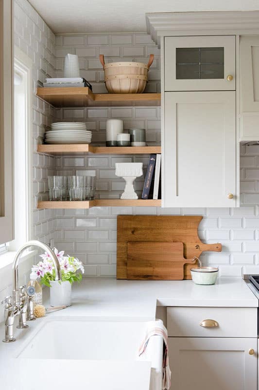 Corner kitchen design with floating shelves and Cabinets, subway tiles backsplash, and undermount sink 