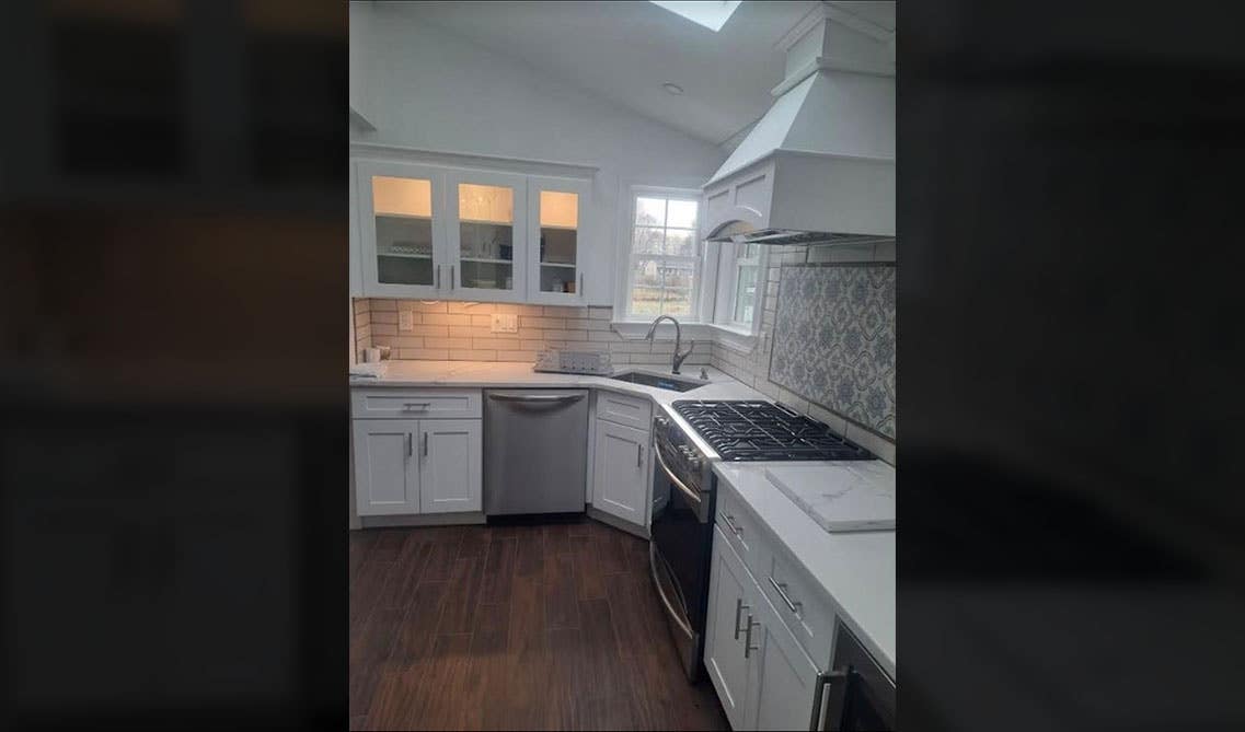 Corner Sink Kitchen with white cabinets, white countertop, wooden range hood