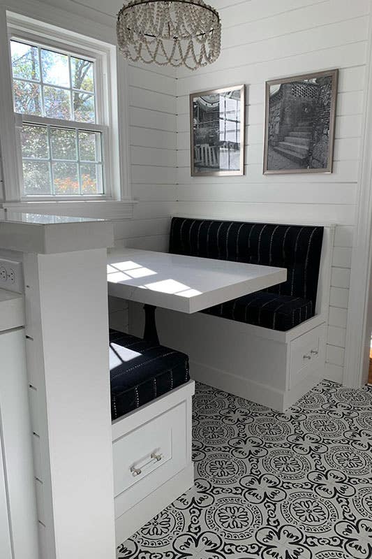 White cabinetry with a cozy breakfast nook with seat cushions