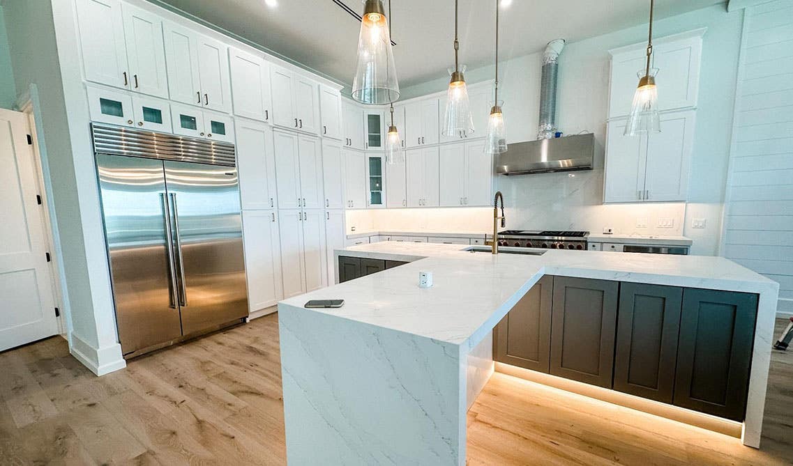 kitchen with white cabinets, l shape island, spc flooring and Cove Lighting