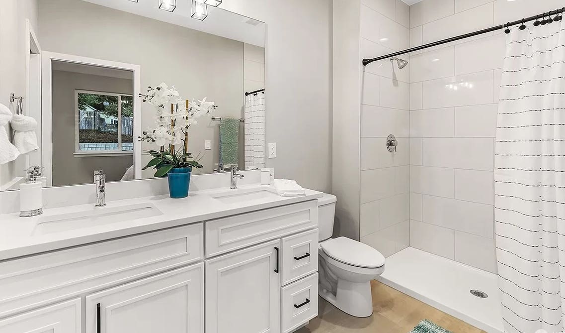 Craftsman white shaker vanity paired with wooden flooring 