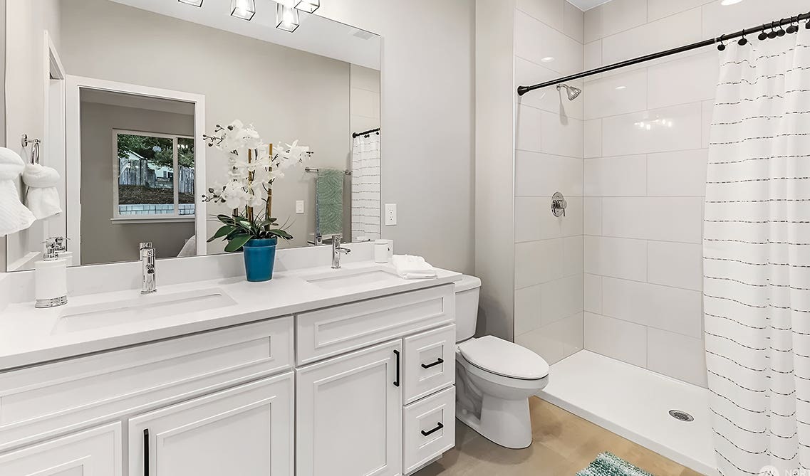 Bathroom design paired with craftsman white vanity, statement lighting, and separate shower area
