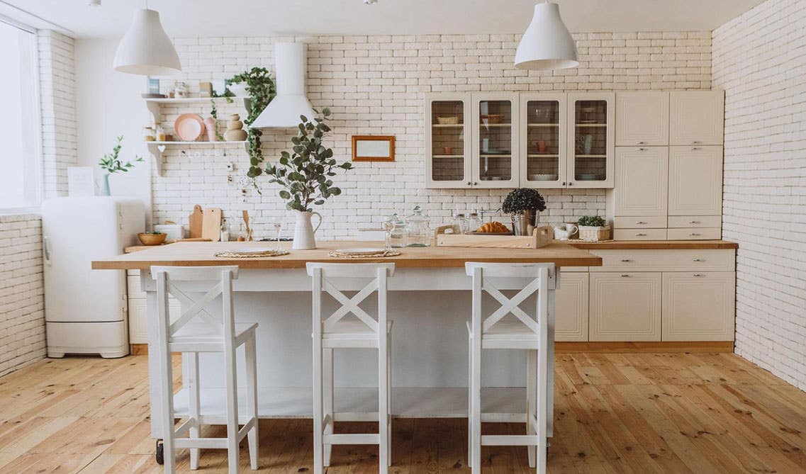 Rustic kitchen design- cream cabinets with glass door, Wood island and chairs, brick style backsplashes and wooden flooring